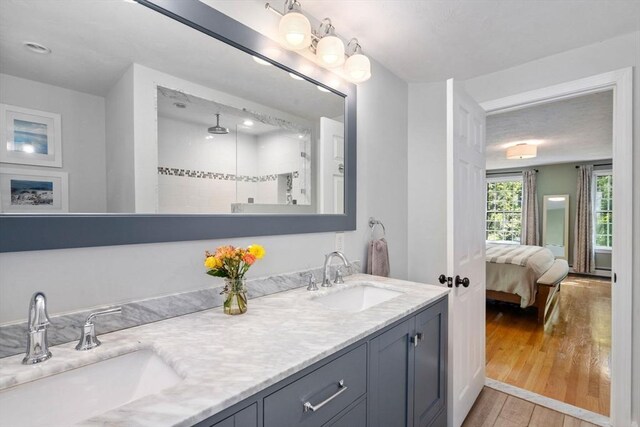 48 Pine Hill Dr, Walpole, MA 02081 - full bathroom with wood-type flooring, double vanity, connected bathroom, and tiled shower