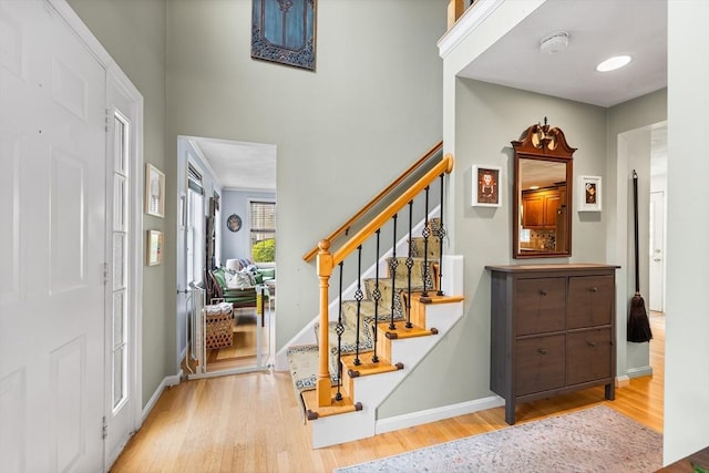 foyer entrance featuring wood finished floors, stairs, and baseboards