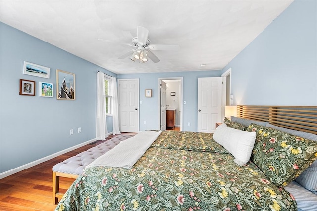 bedroom with baseboards, wood finished floors, ensuite bath, and a ceiling fan