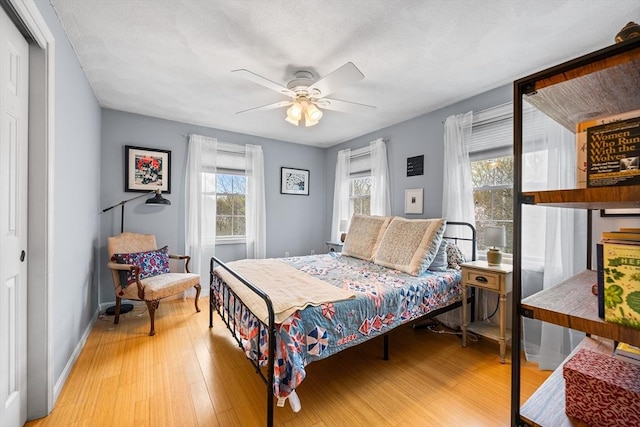 bedroom featuring multiple windows, wood finished floors, and baseboards