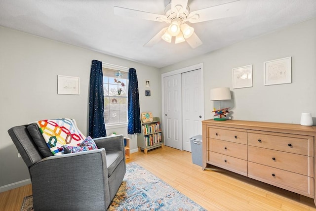 living area featuring light wood-style flooring, ceiling fan, and baseboards