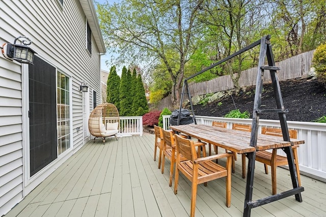 wooden terrace featuring a fenced backyard and outdoor dining area