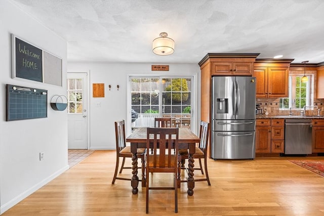 dining area featuring baseboards and light wood-style floors