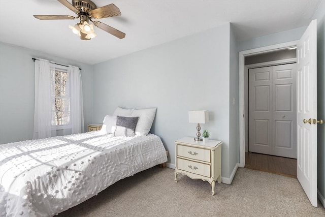 bedroom with ceiling fan, light carpet, and a closet