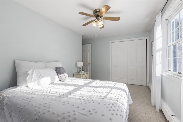 carpeted bedroom with ceiling fan, baseboard heating, and a closet