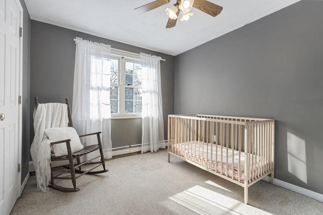 carpeted bedroom with ceiling fan and a nursery area