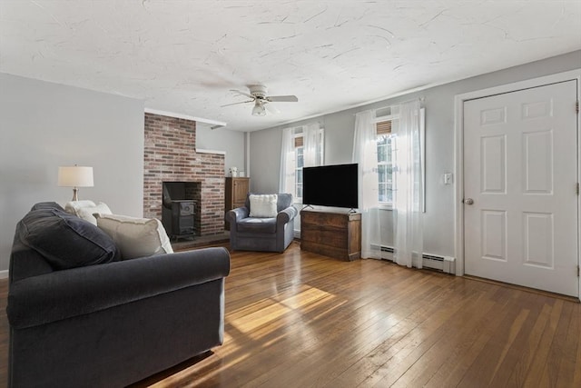 living room with ceiling fan, a baseboard radiator, and hardwood / wood-style floors