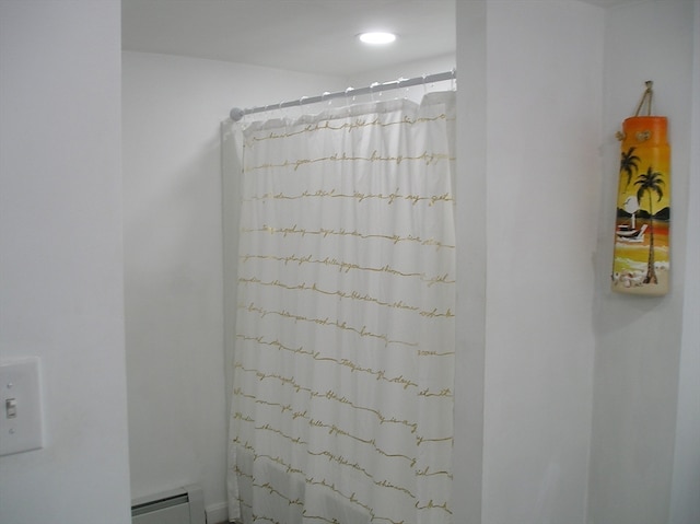 bathroom featuring a baseboard heating unit and curtained shower