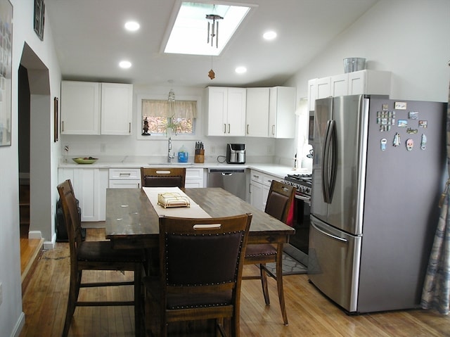 kitchen featuring a center island, appliances with stainless steel finishes, light hardwood / wood-style flooring, and white cabinets