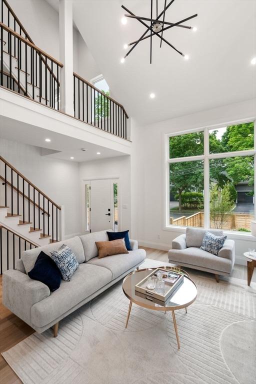 19 Johnson Pl Unit 19, Newton, MA 02466 - living room with stairs, wood finished floors, a towering ceiling, a chandelier, and baseboards
