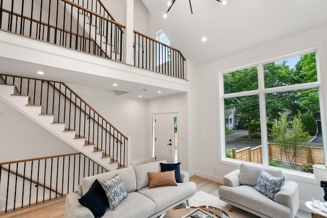 19 Johnson Pl Unit 19, Newton, MA 02466 - living area with wood finished floors, a towering ceiling, stairway, baseboards, and recessed lighting