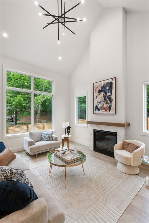 19 Johnson Pl Unit 19, Newton, MA 02466 - living area with wood finished floors, high vaulted ceiling, a premium fireplace, a chandelier, and baseboards