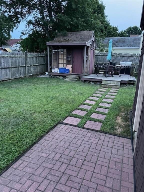 80 Andover, Peabody, MA 01960 - view of yard featuring a deck, a fenced backyard, a storage shed, and an outbuilding