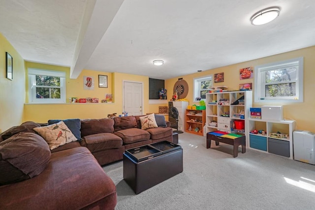 carpeted living area with beam ceiling