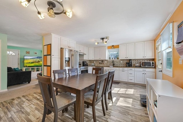 dining area featuring light wood-style floors and a chandelier