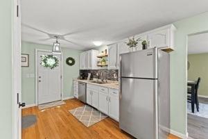 19 Station St, Wareham, MA 02571 - kitchen featuring appliances with stainless steel finishes, light wood-style floors, white cabinetry, tasteful backsplash, and light countertops