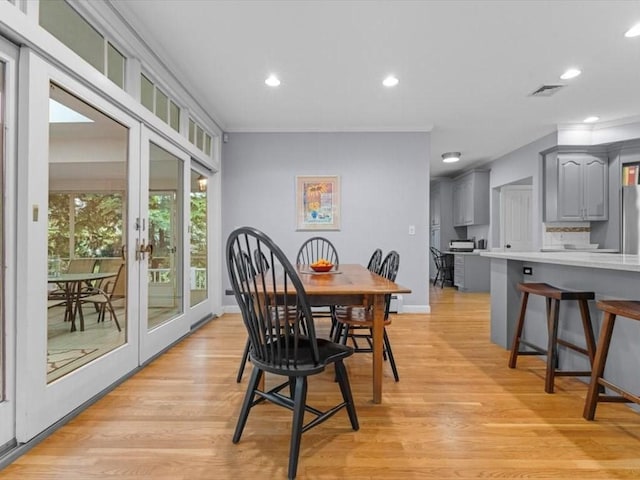 dining space featuring light wood-style flooring, recessed lighting, crown molding, baseboards, and french doors