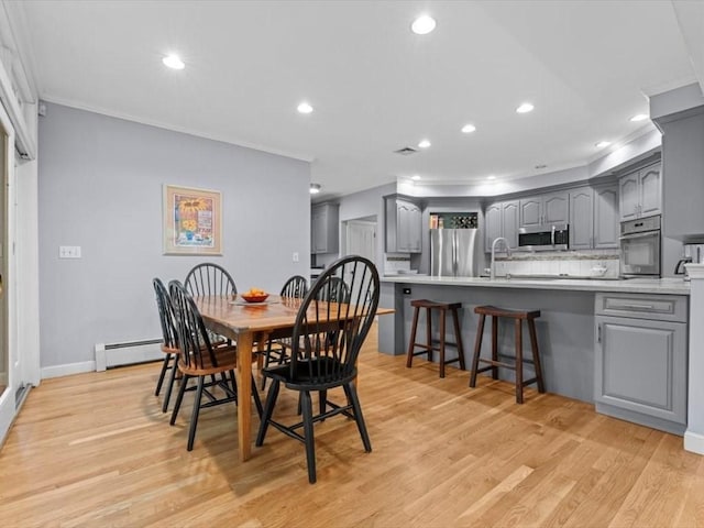 dining area with recessed lighting, crown molding, a baseboard radiator, light wood-style floors, and baseboards