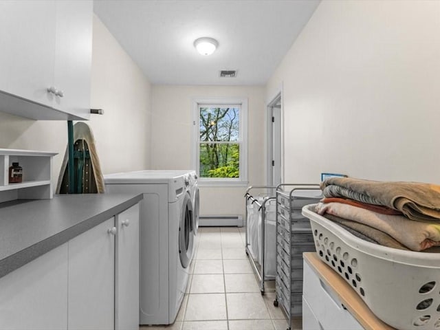 washroom with independent washer and dryer, a baseboard heating unit, cabinet space, and light tile patterned floors