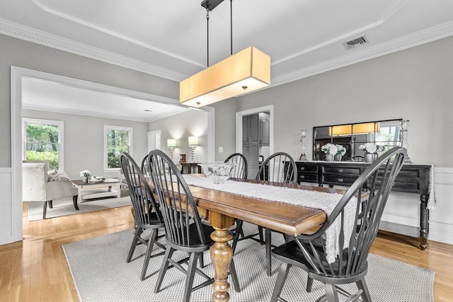 dining area featuring crown molding and light wood-style flooring