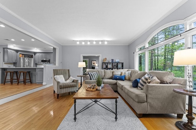 living area featuring healthy amount of natural light, light wood-style floors, crown molding, and recessed lighting