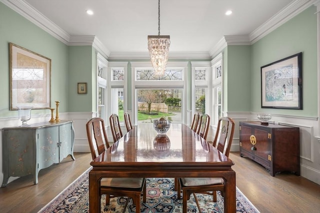 dining room with light wood-type flooring, a chandelier, ornamental molding, and recessed lighting