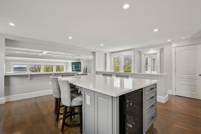 kitchen featuring recessed lighting, light countertops, baseboards, and wine cooler