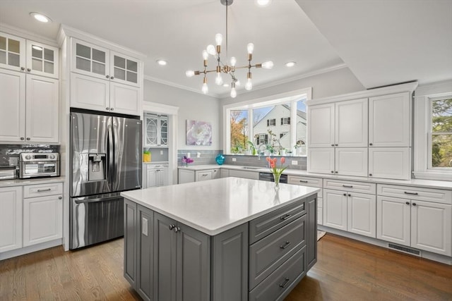 kitchen with white cabinetry, a kitchen island, stainless steel refrigerator with ice dispenser, and gray cabinets