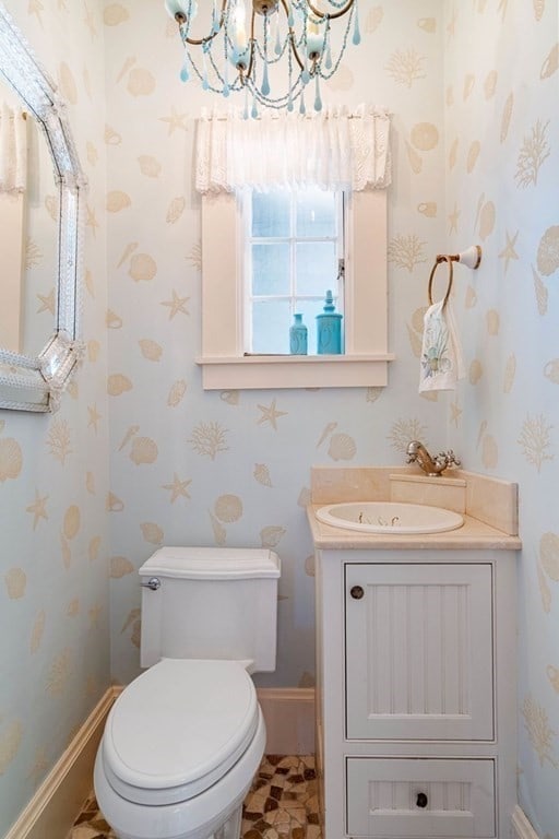 bathroom featuring tile flooring, toilet, vanity, and a chandelier