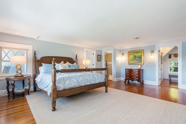 bedroom with dark wood-type flooring and crown molding