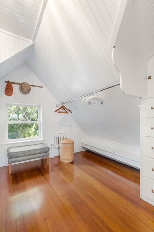 additional living space featuring radiator heating unit, vaulted ceiling, and wood-type flooring