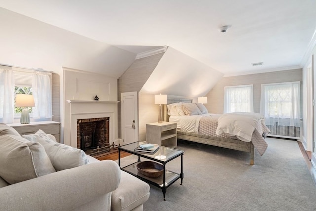 bedroom with access to exterior, a brick fireplace, vaulted ceiling, and wood-type flooring