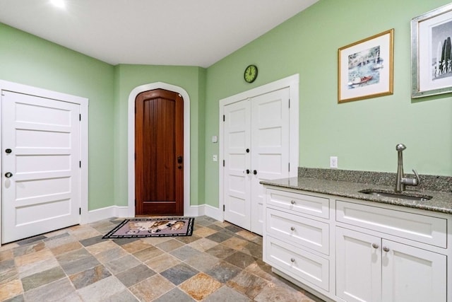 foyer entrance featuring dark tile flooring and sink