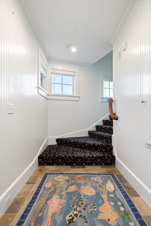 stairway featuring tile floors and ornamental molding