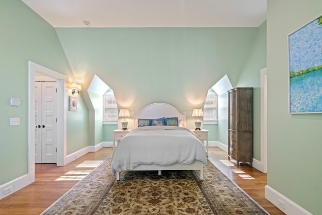 bedroom featuring light hardwood / wood-style flooring and vaulted ceiling