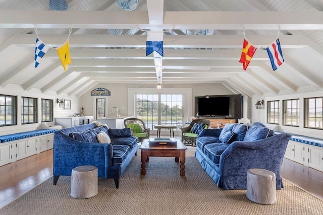 living room featuring vaulted ceiling with beams and light hardwood / wood-style flooring