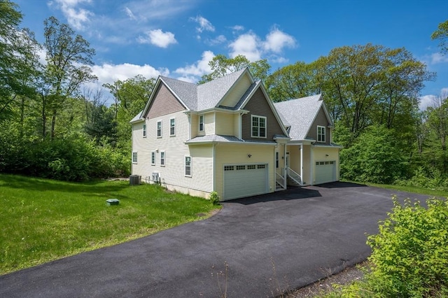 233A Green St, Boylston, MA 01505 - view of side of home with an attached garage, asphalt driveway, central AC unit, a lawn, and a shingled roof