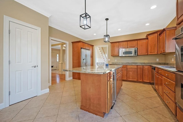 kitchen featuring light stone counters, light tile patterned floors, a kitchen island, stainless steel appliances, and crown molding