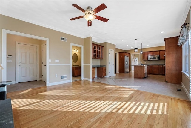 unfurnished living room featuring light wood-style flooring, visible vents, and ornamental molding