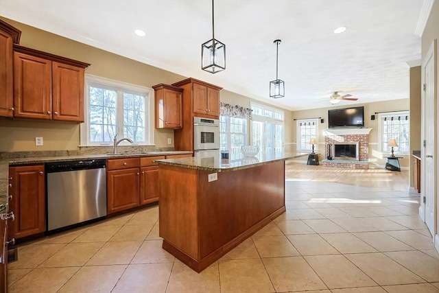 kitchen with a sink, open floor plan, a center island, light tile patterned floors, and dishwasher