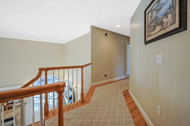 hallway with wood finished floors, recessed lighting, baseboards, and visible vents