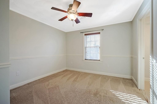 empty room featuring ceiling fan, carpet, baseboards, and ornamental molding