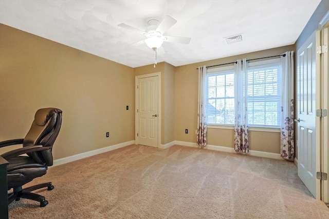 office space with visible vents, baseboards, light colored carpet, and ceiling fan