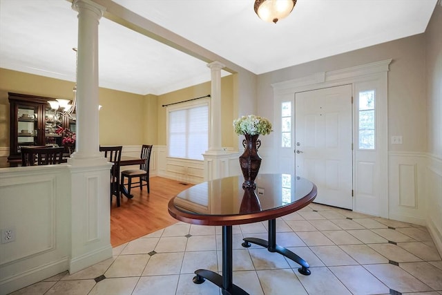 entryway featuring a wealth of natural light, light tile patterned flooring, and ornate columns