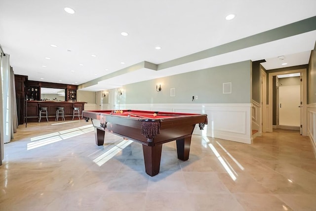 recreation room with billiards, recessed lighting, wainscoting, a dry bar, and a decorative wall