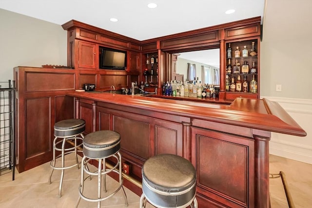 bar featuring light tile patterned floors, indoor wet bar, and recessed lighting