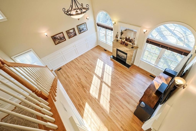 living room with a high ceiling, a decorative wall, light wood-style flooring, and a wealth of natural light