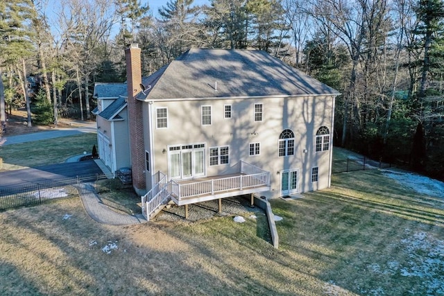 exterior space featuring a yard, a deck, a chimney, and fence