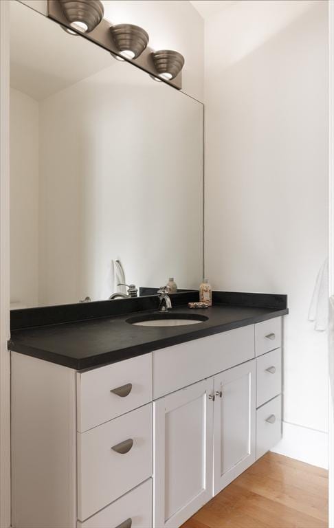 bathroom with wood finished floors and vanity