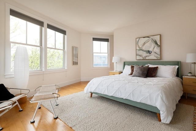 bedroom featuring light wood finished floors and baseboards